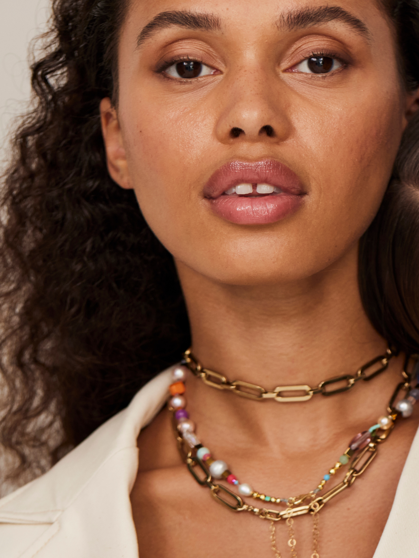Eine wunderschöne Frauen schaut in die Kamera und trägt tollen, exzentrischen Schmuck mit hohem Designanspruch.