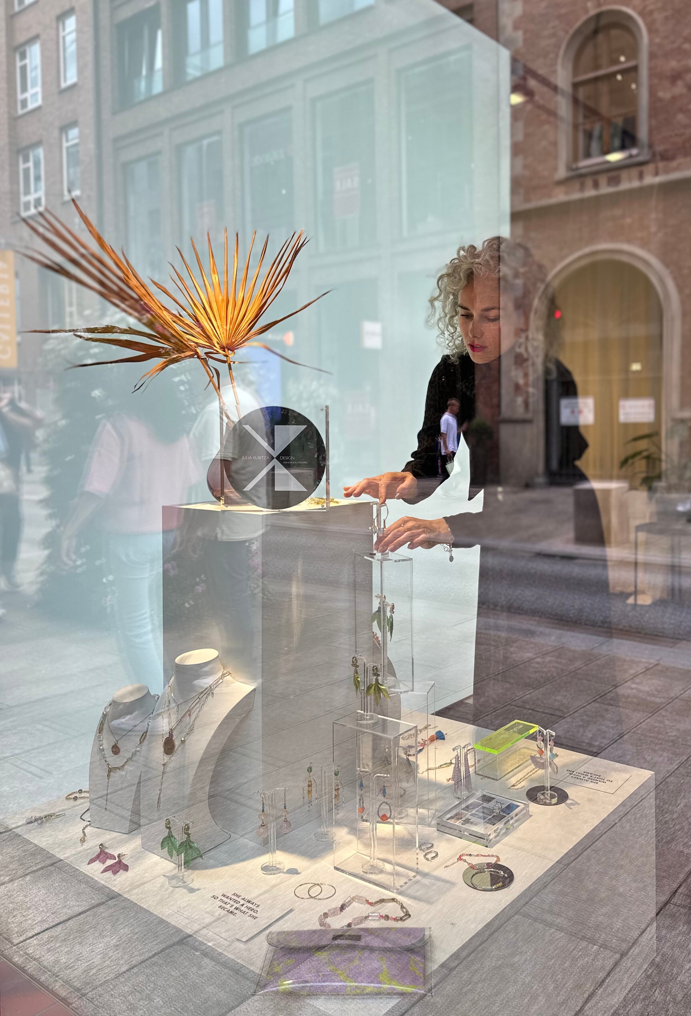 designerin julia kubitza in ihrem pop up in Hamburg dekoriert schmuck und modeaccessoires