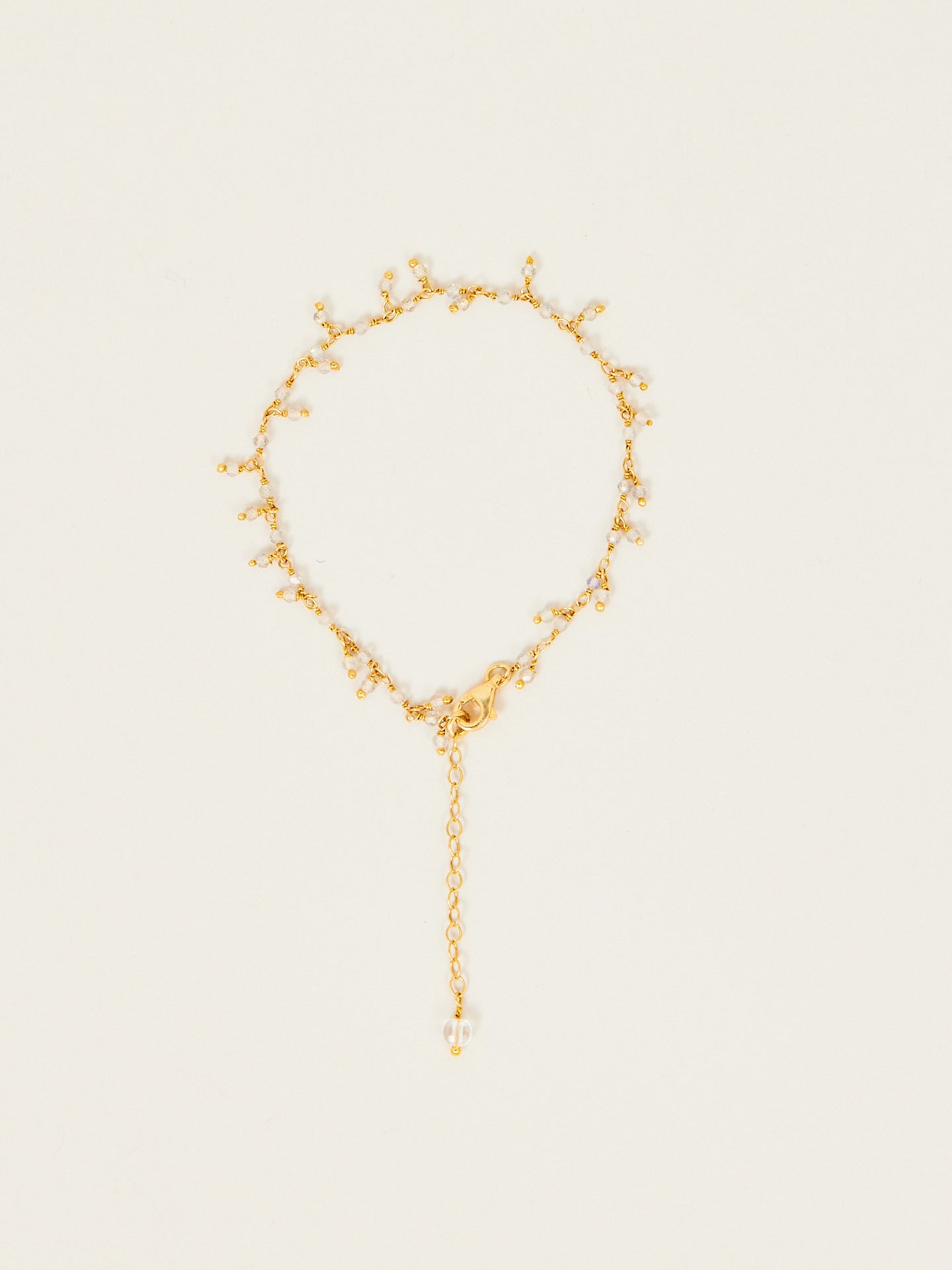Goldenes verspieltes Armband mit langem Anhänger.