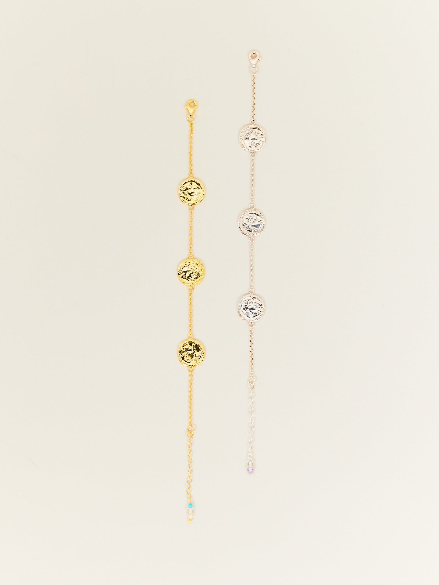 Ein goldenes sowie ein bicolores Armband mit silbernen und goldenen Münzen.