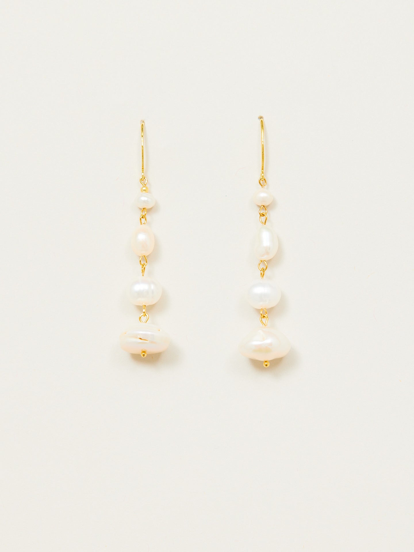 Aufregendes Ohrringpaar bestehend aus weissen Perlen und goldenem Anteil